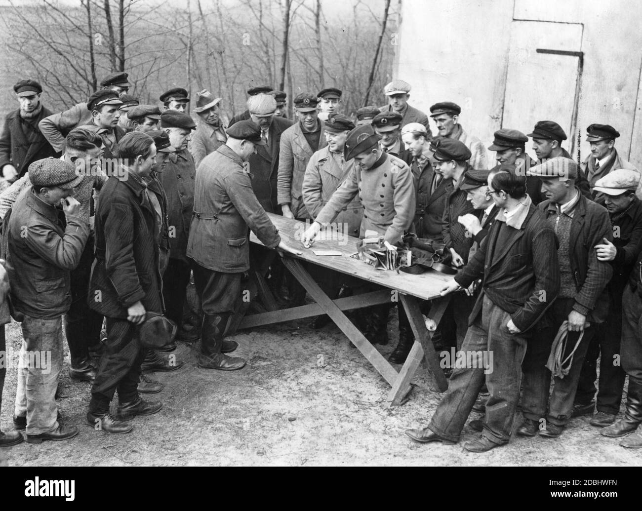 Premier paiement de salaire aux travailleurs d'urgence du Service forestier d'État. À la table, il y a un fonctionnaire forestier dans un uniforme forestier (Litewka). Banque D'Images