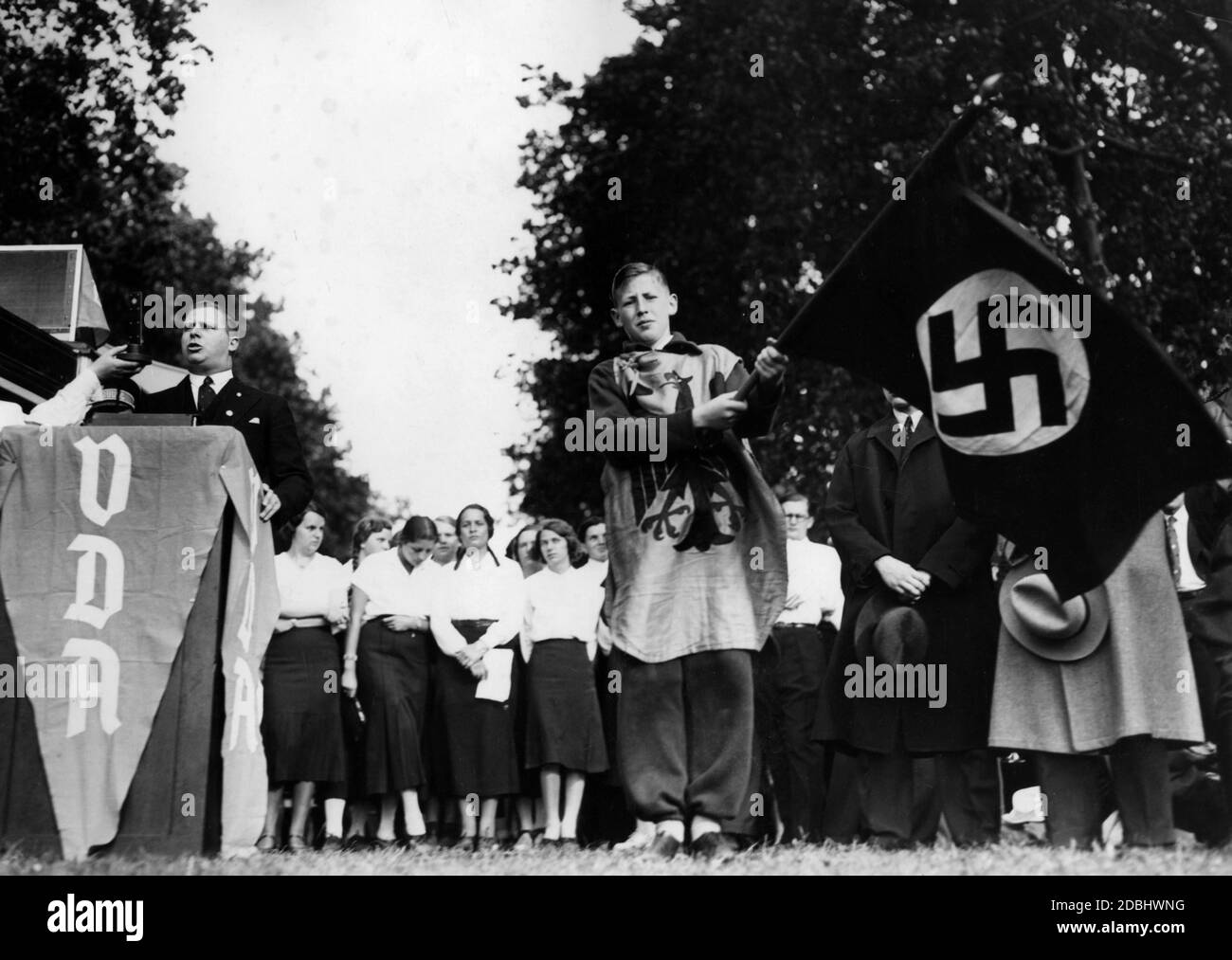 Erich Klinker, chef de la propagande de Reich du VDA, prononce un discours à la ''Volksdeutschen Tag des VDA'' de Treptow, qui a lieu dans le cadre de la semaine de promotion des sports pour les jeunes. Sur la droite, un garçon de la VDA Youth en robe avec l'aigle impérial, portant un drapeau de la croix gammée.' Banque D'Images