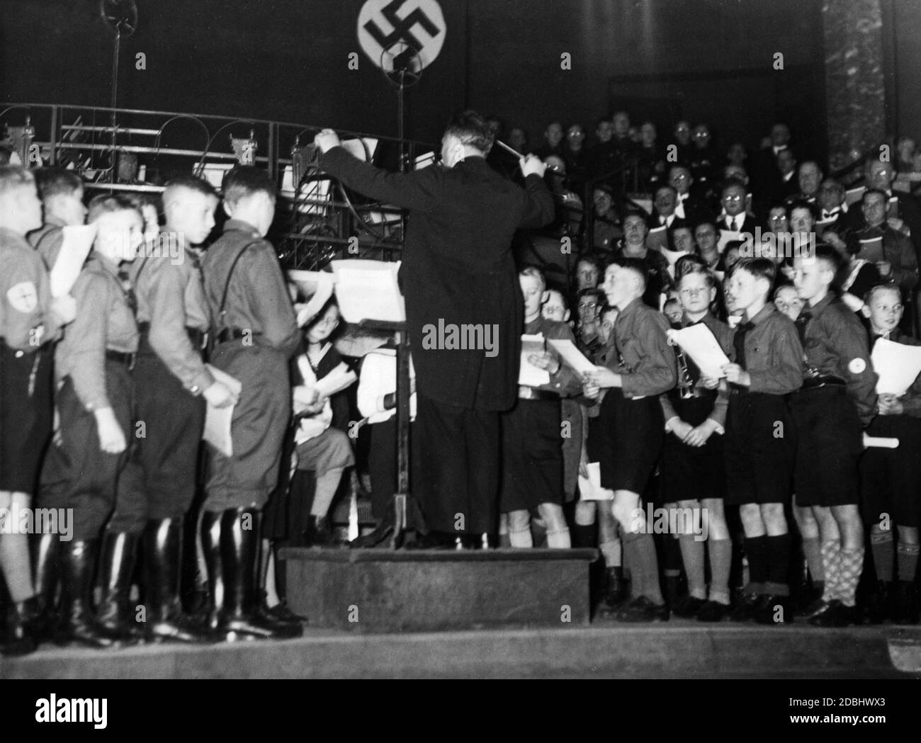 Dans l'Opéra de Berlin Kroll, les classes scolaires et les chorales chantent des chansons folkloriques sous la direction d'un maître de choirte. Banque D'Images