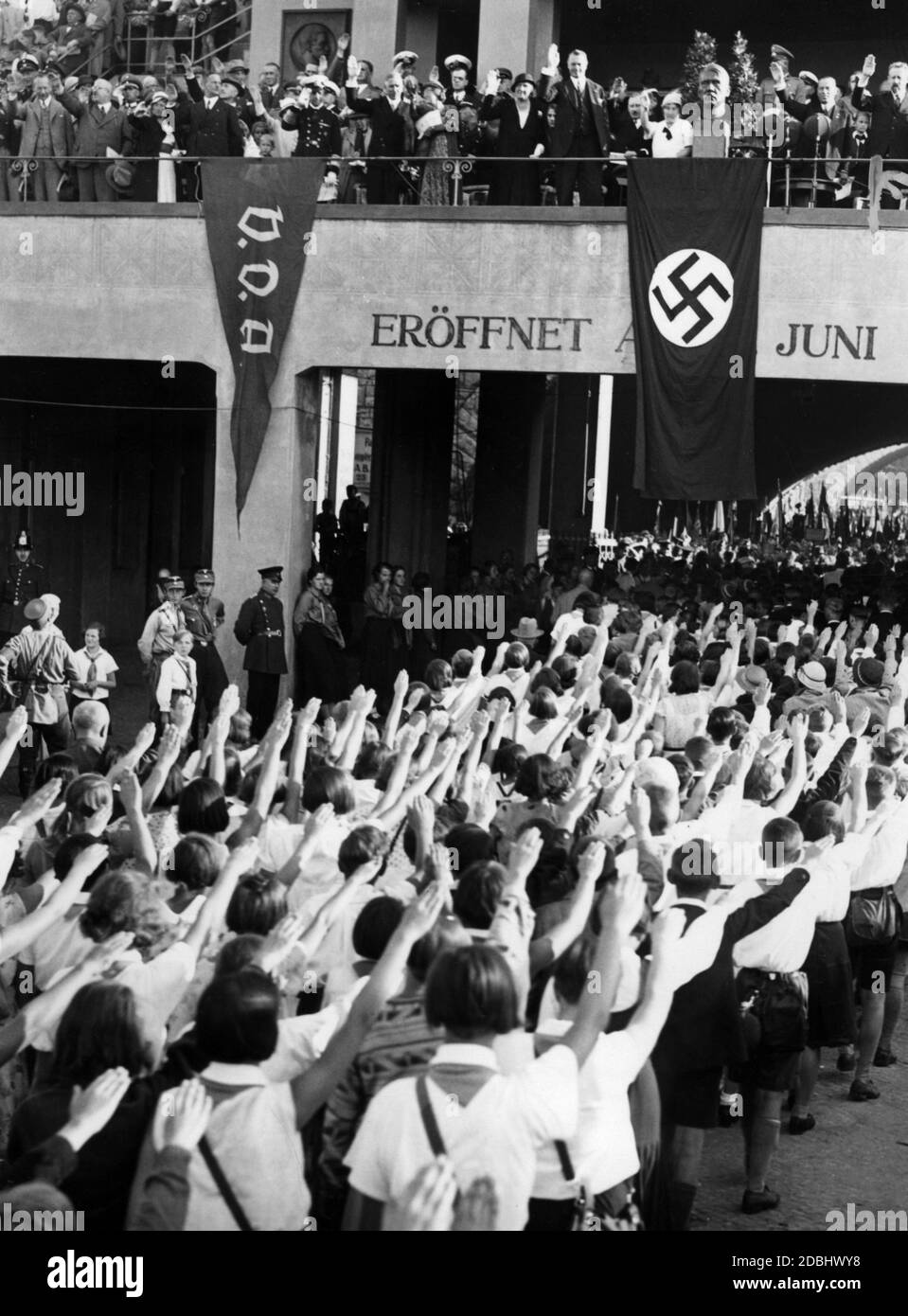 'Au ''Festival of the German School'' du stade Grunewald de Berlin, les élèves saluent la boîte VIP lorsqu'ils sortent du stade. Debout dans la boîte entre autres (du drapeau VDA Erich Raeder, Franz von Papen et le maire de Berlin Heinrich Sahm, et à l'extrême droite le professeur Eugen Fischer, recteur de la Friedrich-Wilhelms-Universitaet Berlin. En outre, un buste de l'Absent Adolf Hitler est placé au-dessus d'un drapeau de la croix gammée. Sur le côté gauche se trouve un drapeau de l'organisateur ''Volksbund fuer das Deutschtum im Ausland', VDA.' Banque D'Images