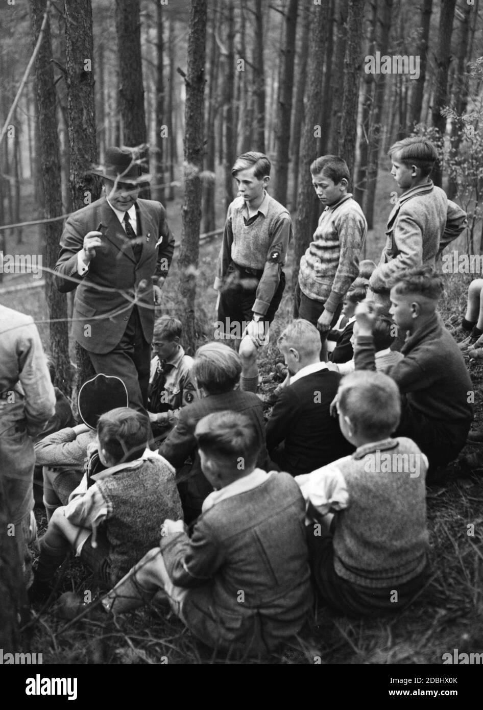 Un professeur et membre du parti donne à ses élèves des instructions pour un jeu sur le terrain le jour de la randonnée. Banque D'Images