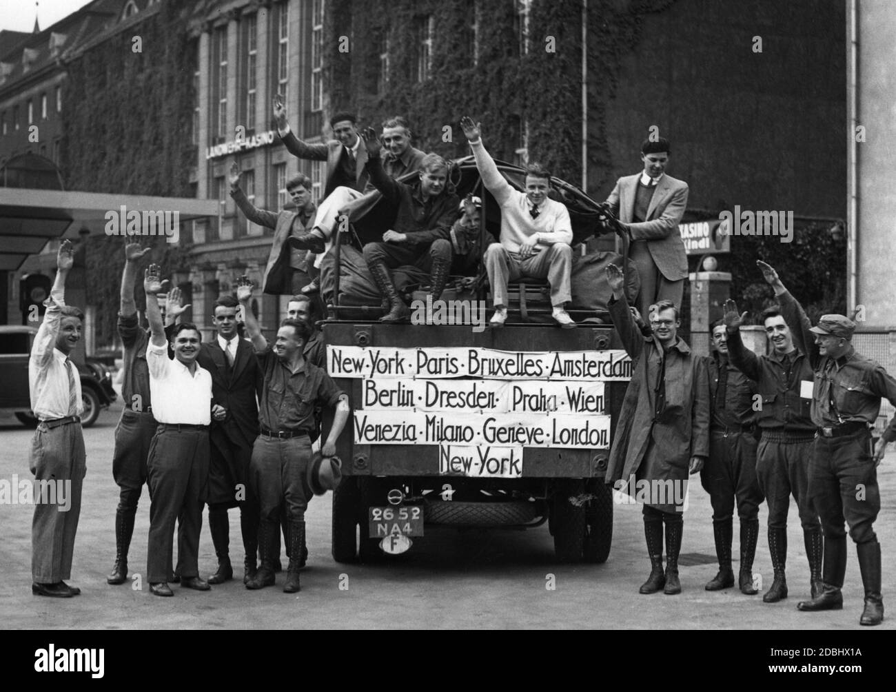Les étudiants américains devant leur maison mobile saluent les nazis lors de leur séjour à Berlin. Dans le bus sont les arrêts principaux de leur tour: New York, Paris, Bruxelles, Amsterdam, Berlin, Dresde, Prague, Vienne, Venise, Milan, Genève, Londres, New York. En arrière-plan, le casino Landwehr. Banque D'Images