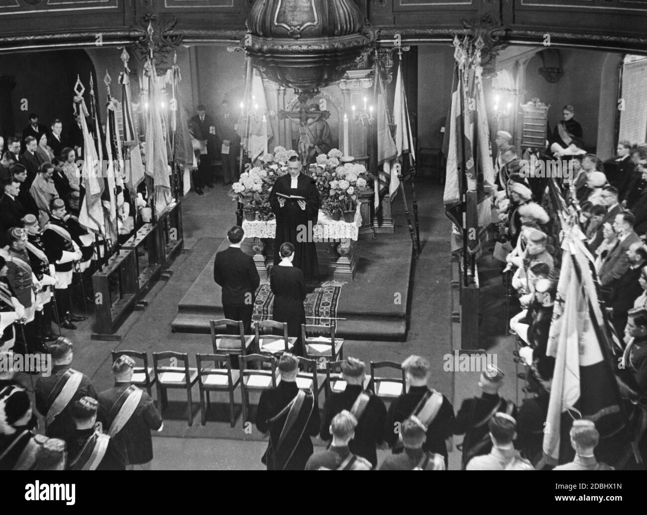 L'aumônier de l'université Ernst Bronisch-Holtze lors d'un sermon au début du semestre dans l'église protestante de la Sainte Trinité de Berlin devant les étudiants en tenue complète. Banque D'Images