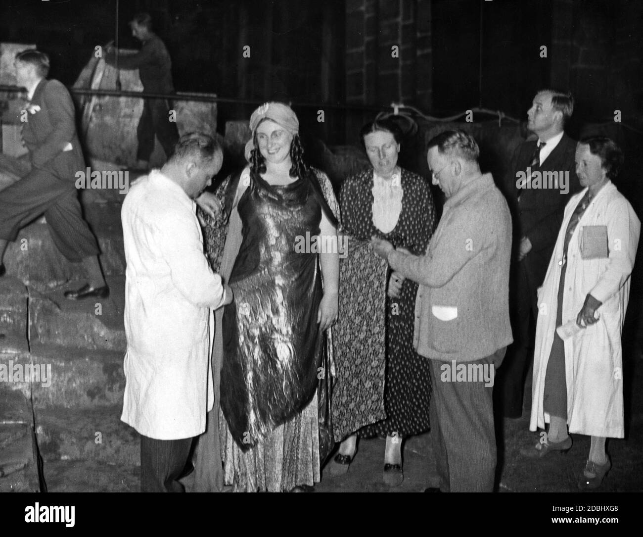Le costume de Kundry (joué par Marta Fuchs) est étroitement inspecté par le directeur du costume Kurt Palm (à gauche), le directeur Heinz Tietjen (à droite) et le directeur du festival Winifred Wagner. Banque D'Images
