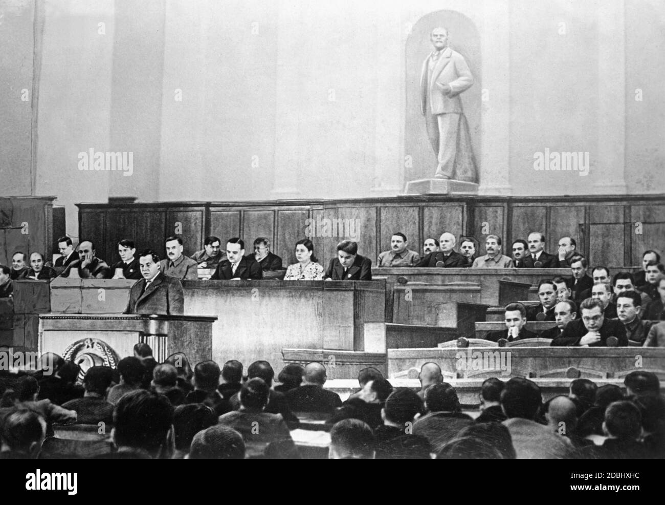 Le chef officiel de l'Union soviétique était Mikhail Kalinin, qui est resté en arrière-plan au mur avec Georgy Malenkov. L'orateur est le commissaire populaire de la finance A. Zverev. Sous la statue de Lénine, de droite à gauche : L. Beria, V. Molotov, A. Mikejan, Y. Staline, K. Voroshilov, N. Khrouchtchev, L. Kaganovich, A. Zhdanov. Derrière le pupitre de gauche à droite : T. Lysenko, U. Yusupov, A. Andreyev, N. Shvernik, CH. Aslanova et M. Kulafin. Banque D'Images