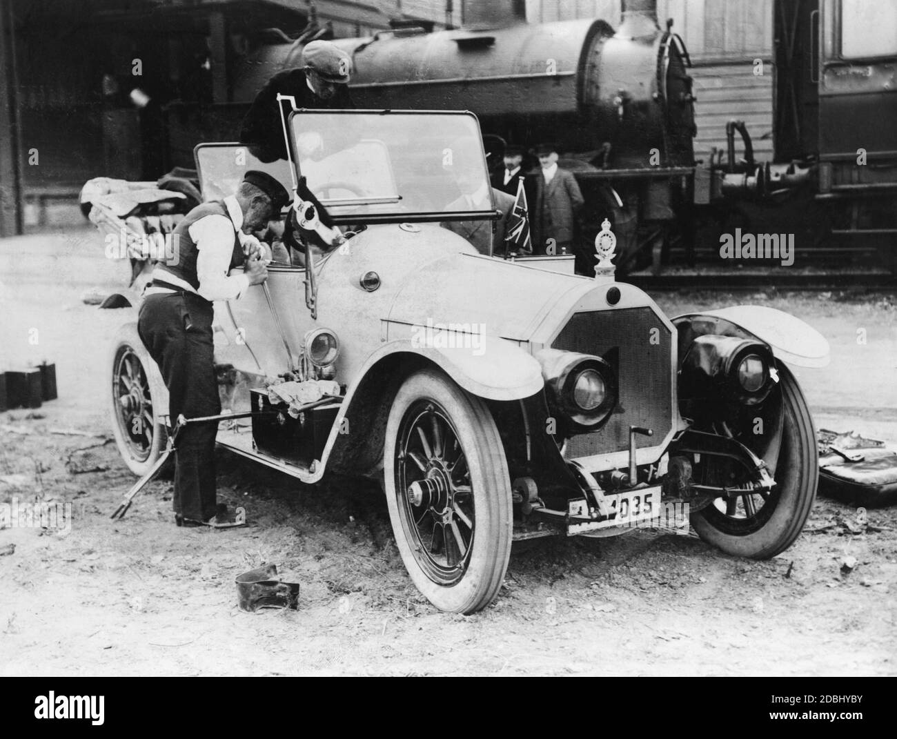 Le prince Henry de Prusse (avant gauche) répare sa voiture de course, avec laquelle il participe au dernier Prinz-Heinrich-Fahrt en 1911. Heinrich actionne le levier de vitesses, qui était à l'extérieur de la voiture, le frein à main est suspendu au sol derrière lui. La voiture est un modèle de production de la marque Benz (Benz 8 avec 18 ch). Le Prinz-Heinrich-Fahrt de 1911 n'était pas une course, mais un aller-retour. Banque D'Images