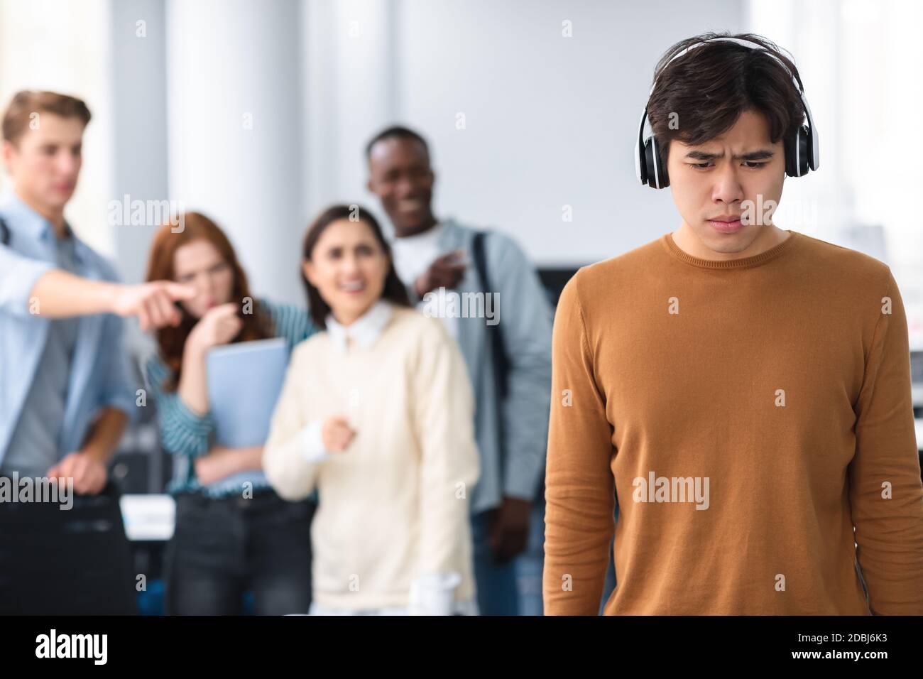 Les gens se moquer et se moquer d'un triste homme asiatique Banque D'Images