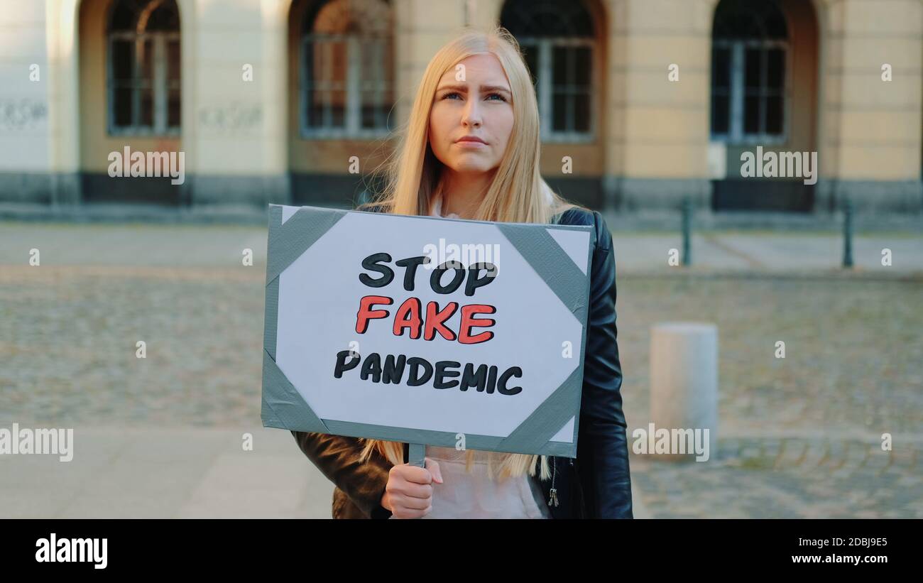 Une jeune femme proteste contre une fausse pandémie. Elle marche dans la rue. Banque D'Images