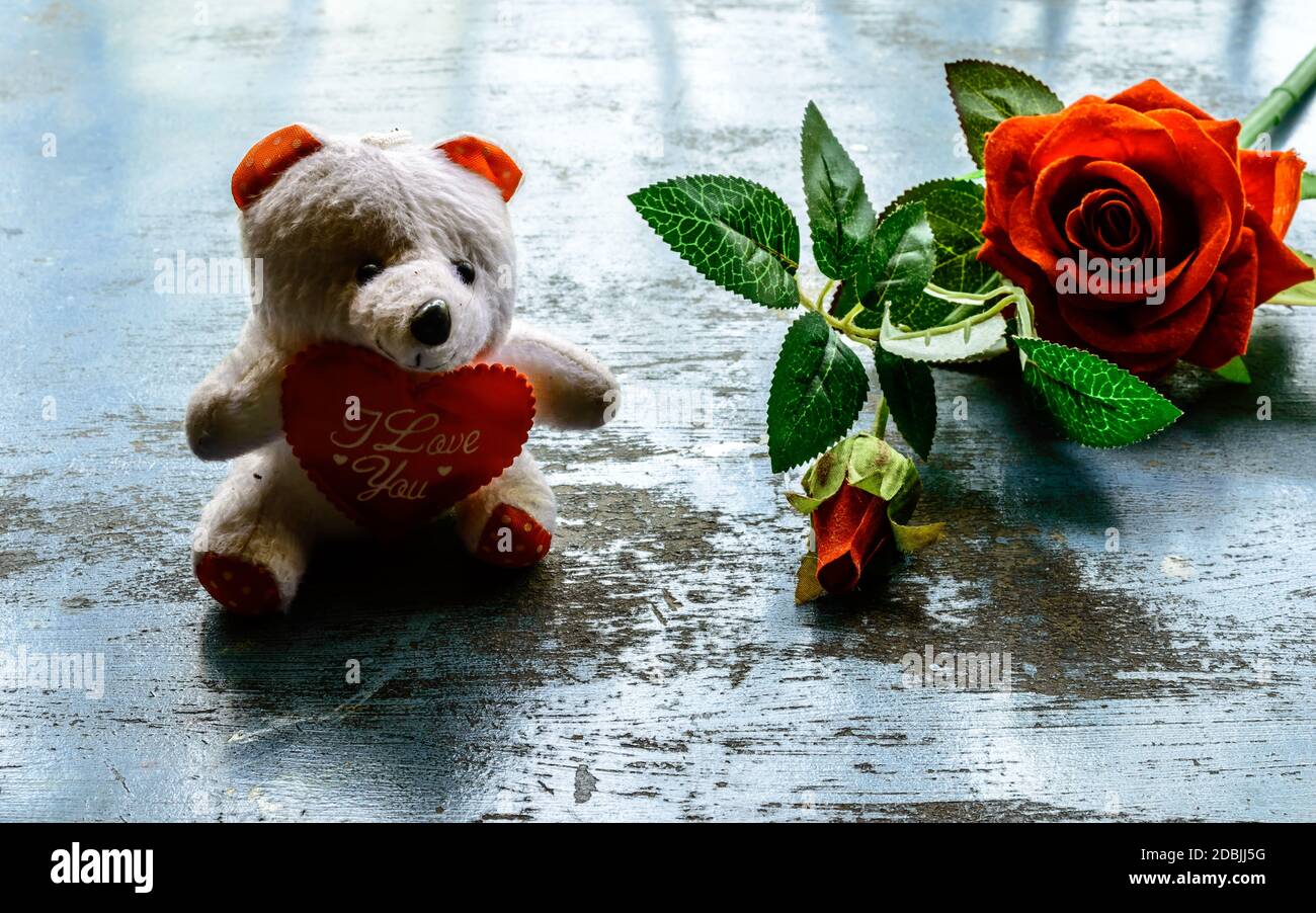 Je vous aime encore la vie romantique thème fond concept pour la Saint Valentin ou l'amitié. Fleur de rose rouge et ours en peluche sur un sol rustique. Papier peint W Banque D'Images