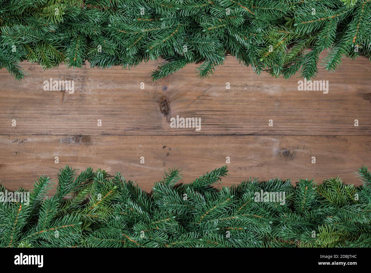 Bordure de branche d'arbre de Noël sur fond de bois. Banque D'Images
