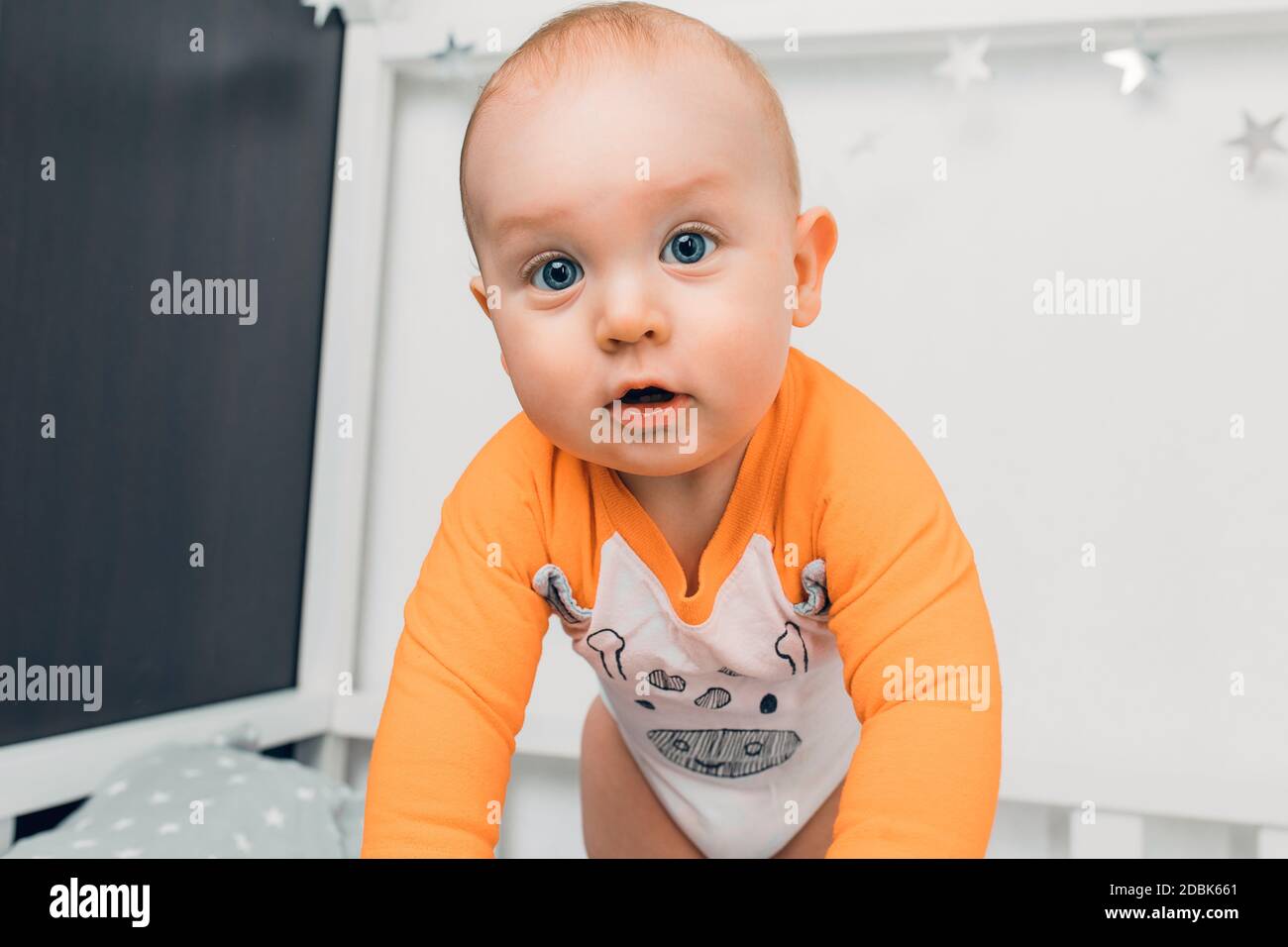 Un petit enfant en pyjama se trouve sur le lit et les langouls, se préparant pour le sommeil Banque D'Images