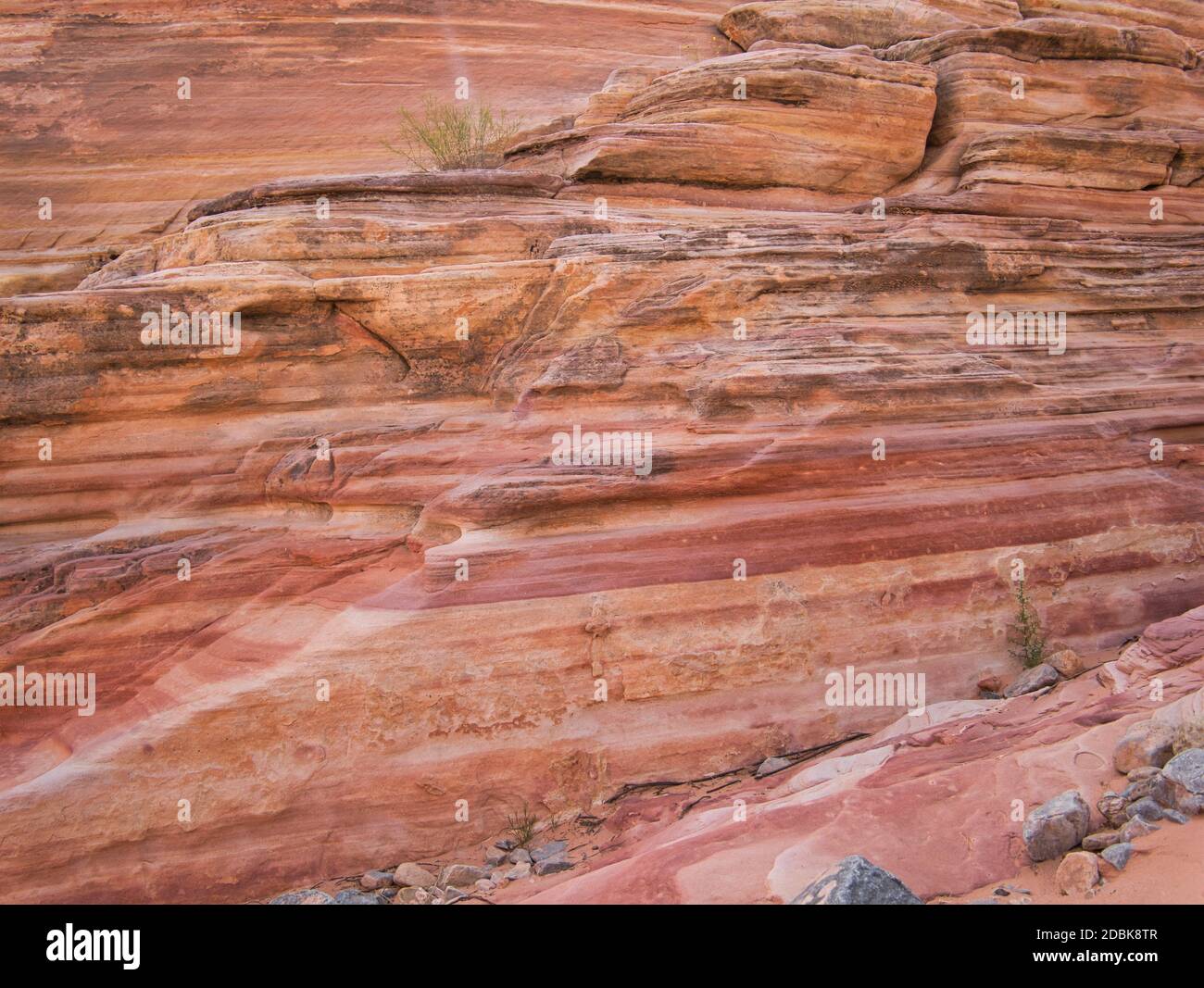 Un grand rocher avec des couches de peinture colorées dans différentes nuances de rouge Banque D'Images