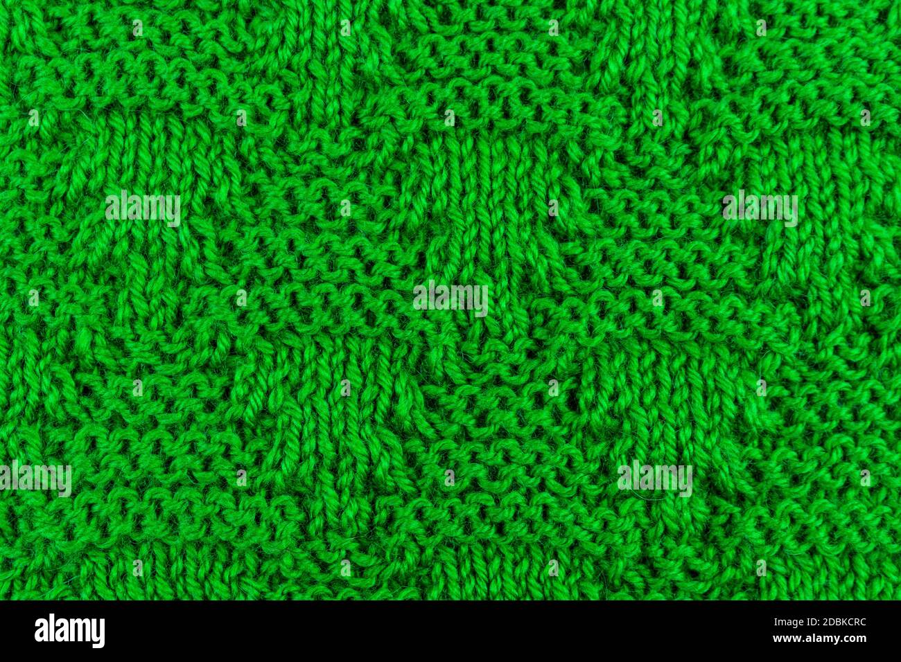 Surface tricotée des objets en laine comme arrière-plan. Gros plan de tissu doux couleur verte texture à motifs tricotés. Vêtements d'hiver chauds. Texte d'arrière-plan Banque D'Images
