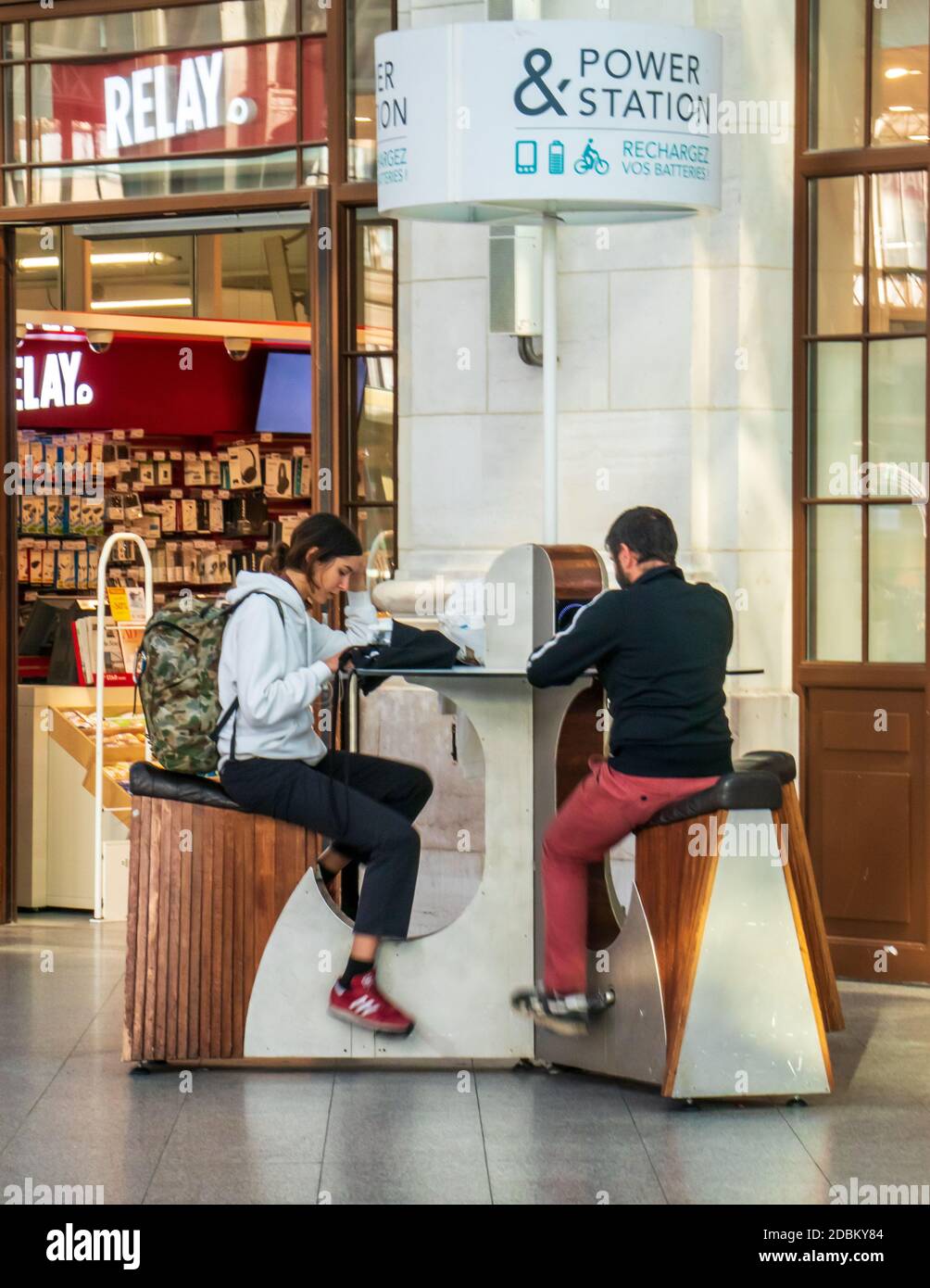 Deux personnes utilisant la centrale pédalo à la Gare du Nord, Paris, France. Banque D'Images