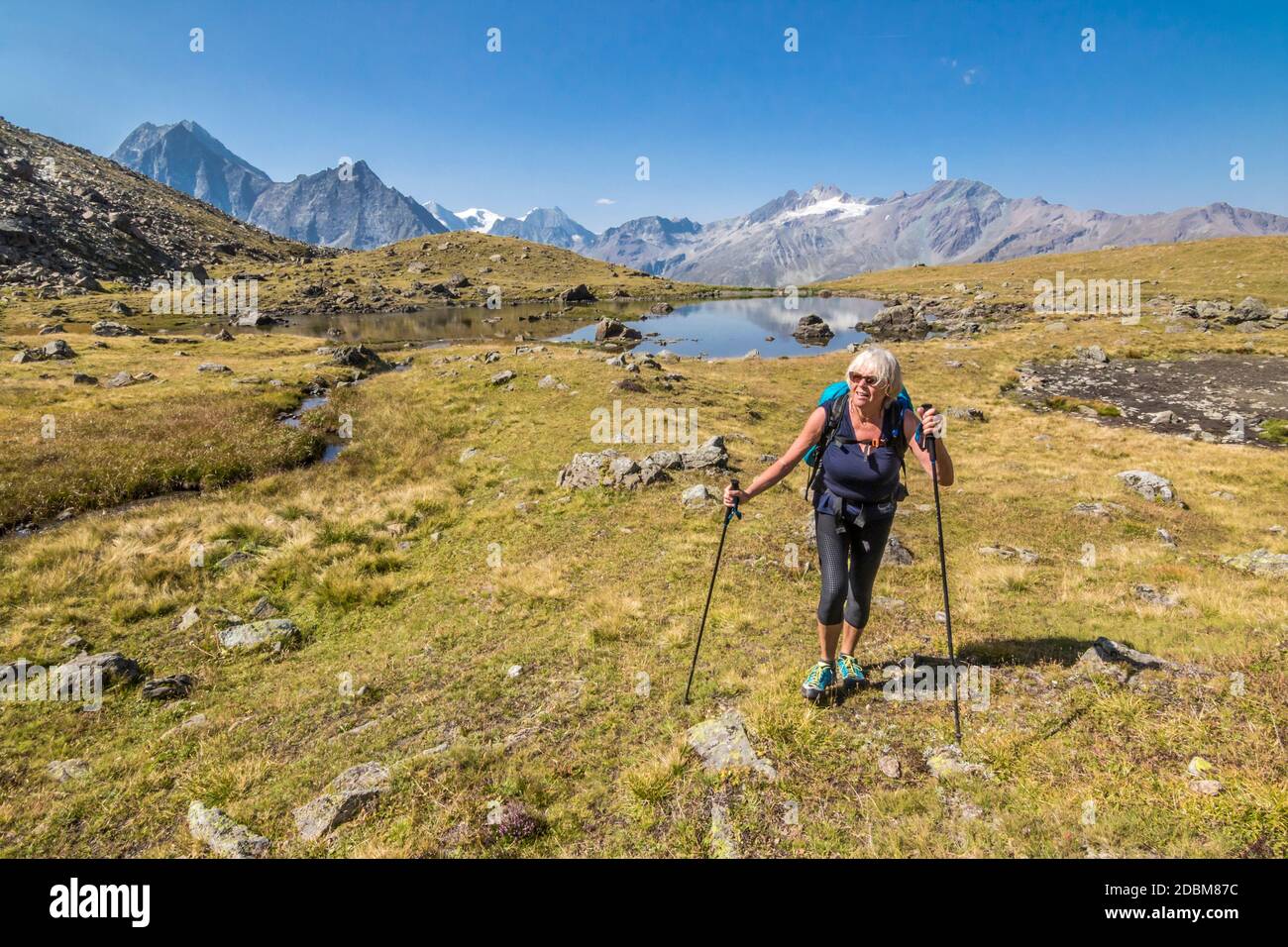 Femme senior randonnée allongÃ‚HauteÃ‚Â route traverse,Ã‚Â ValaisÃ‚Â canton, Suisse Banque D'Images