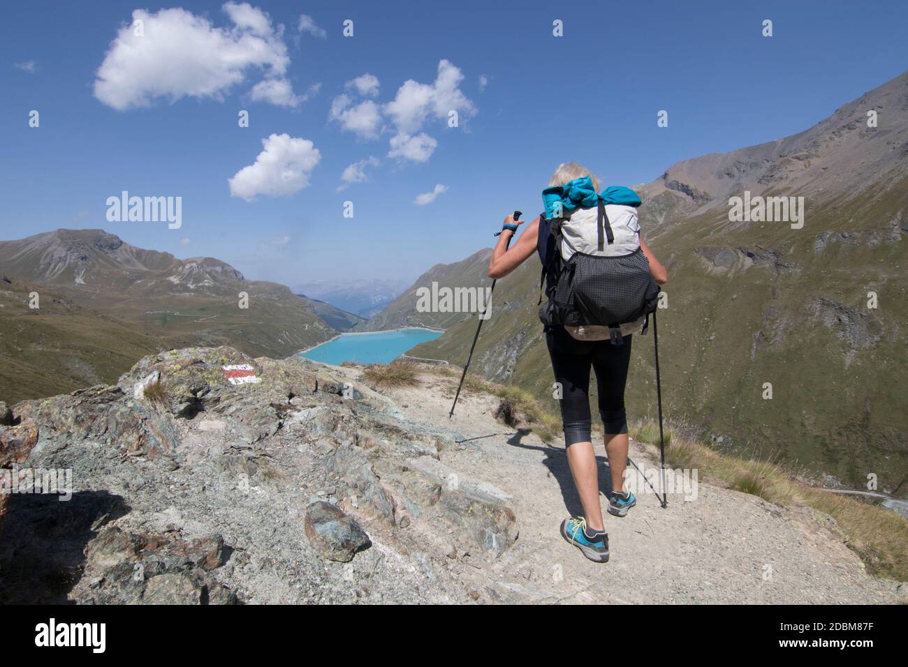 Femme senior randonnée allongÃ‚HauteÃ‚Â route traverse,Ã‚Â ValaisÃ‚Â canton, Suisse Banque D'Images