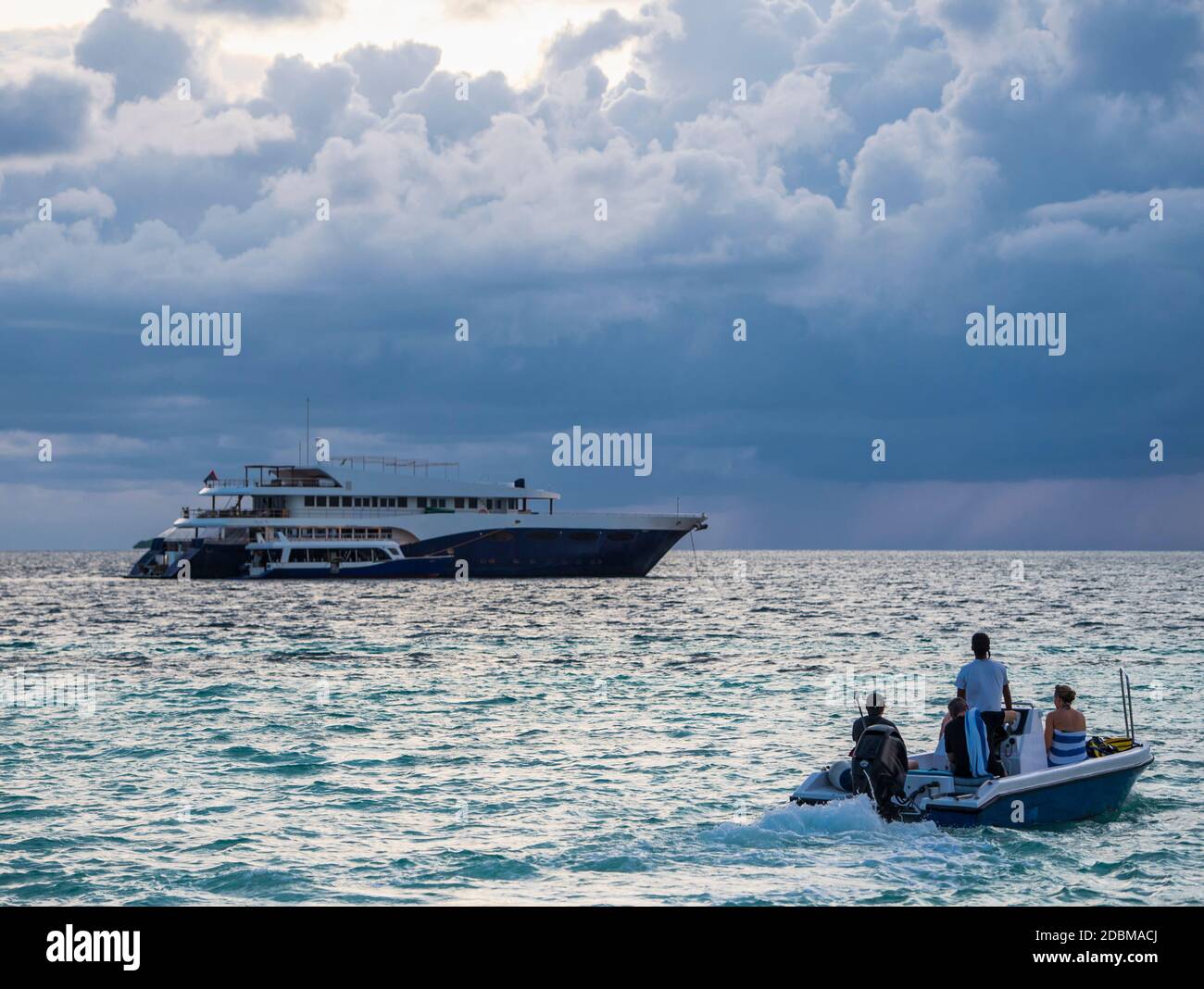 Bateau à moteur transportant des passagers vers un yacht de luxe ancré à Ari Atoll, Maldives Banque D'Images