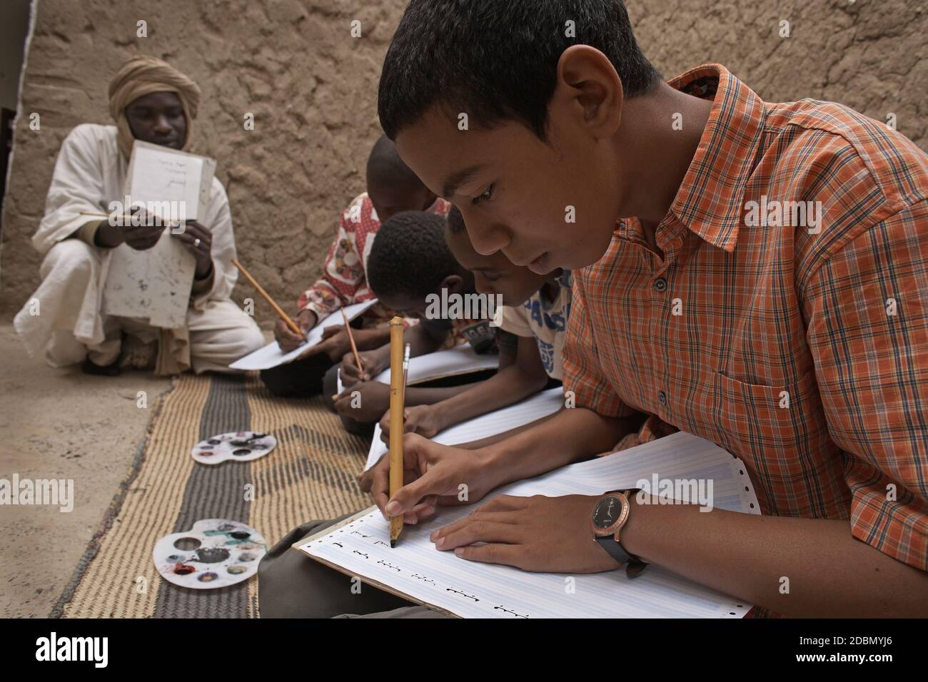 Callligrapher Boubacar Sadek étudie l'art antique de la copie avec les enfants à Tombouctou, Mali Afrique. Banque D'Images