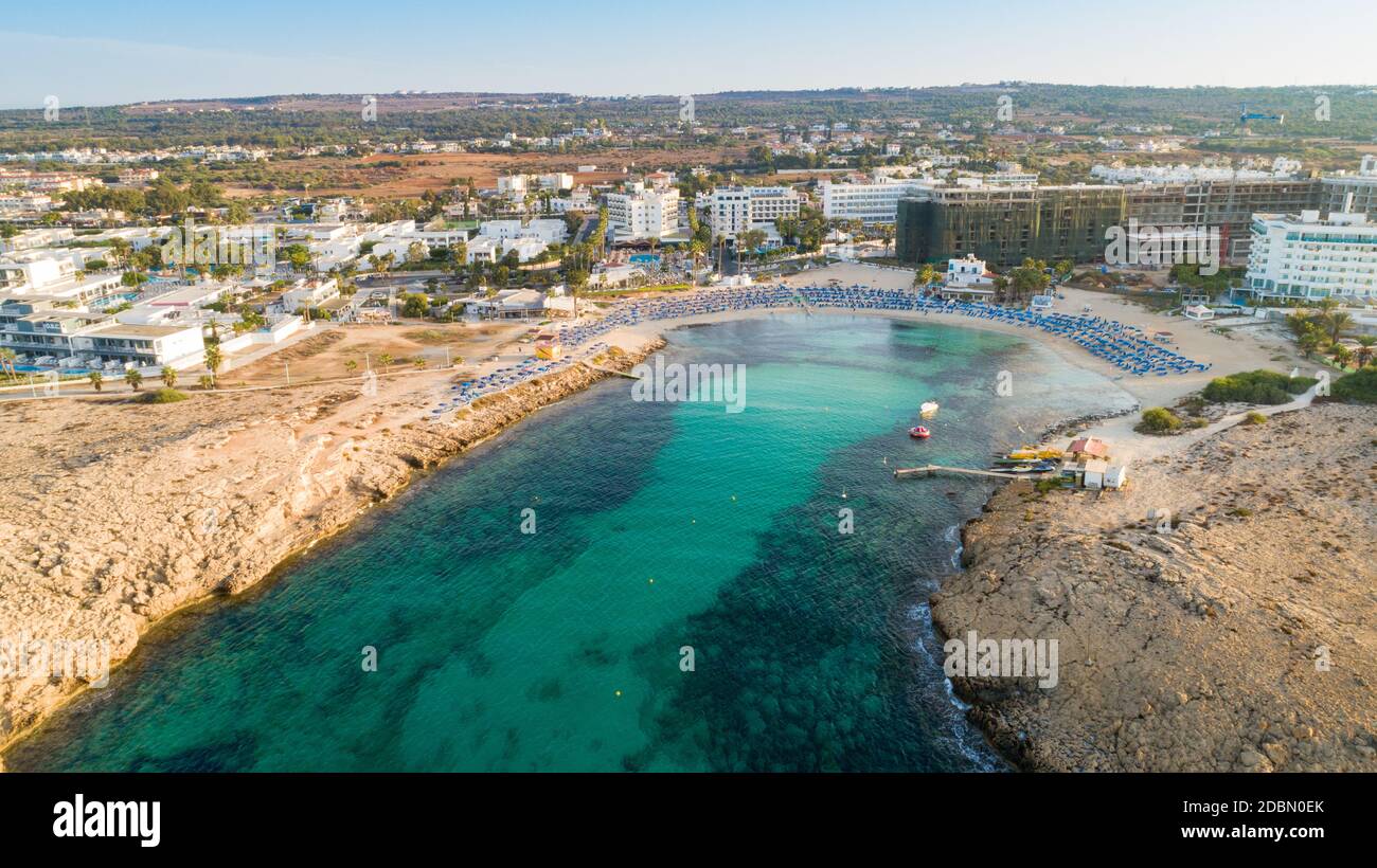 Vue panoramique sur la plage de Vathia Gonia, Ayia Napa, Famagusta, Chypre. L'attraction touristique historique baie rocheuse au lever du soleil avec sable doré, soleil Banque D'Images