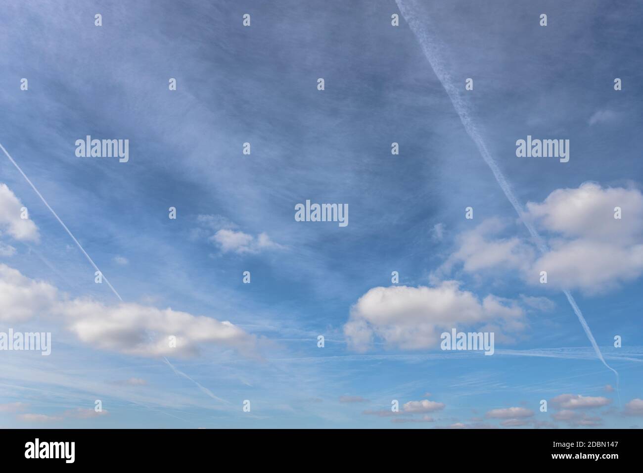 Pistes de jet, connues sous le nom de cheminches ou contrails sur fond bleu ciel avec des glaçures. Banque D'Images