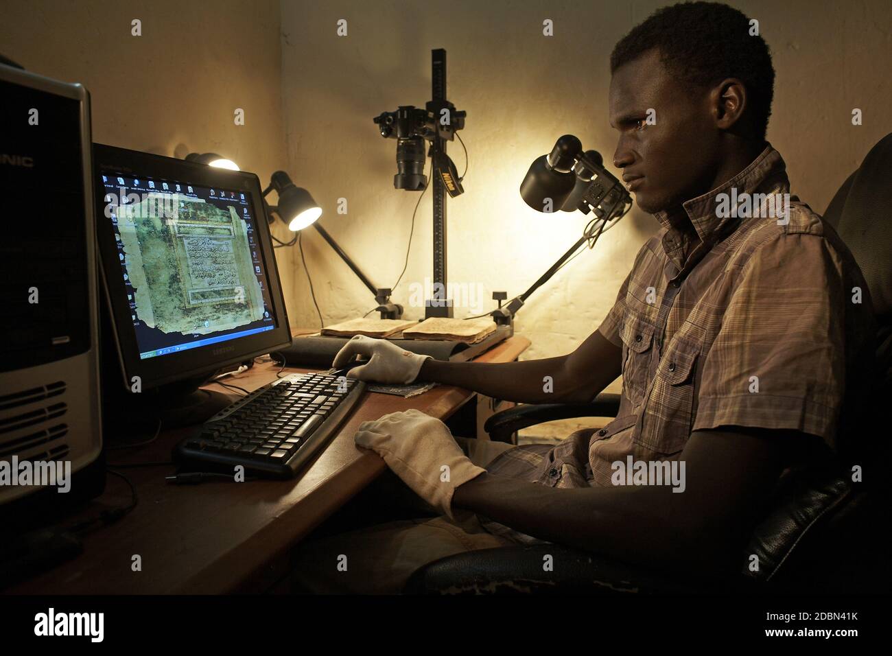 Le fils de Fondo Kati Bibliothek/Ismaël Diadié Kuti est en train de numériser les manuscrits de Tombouctou , Mali, Afrique. Banque D'Images