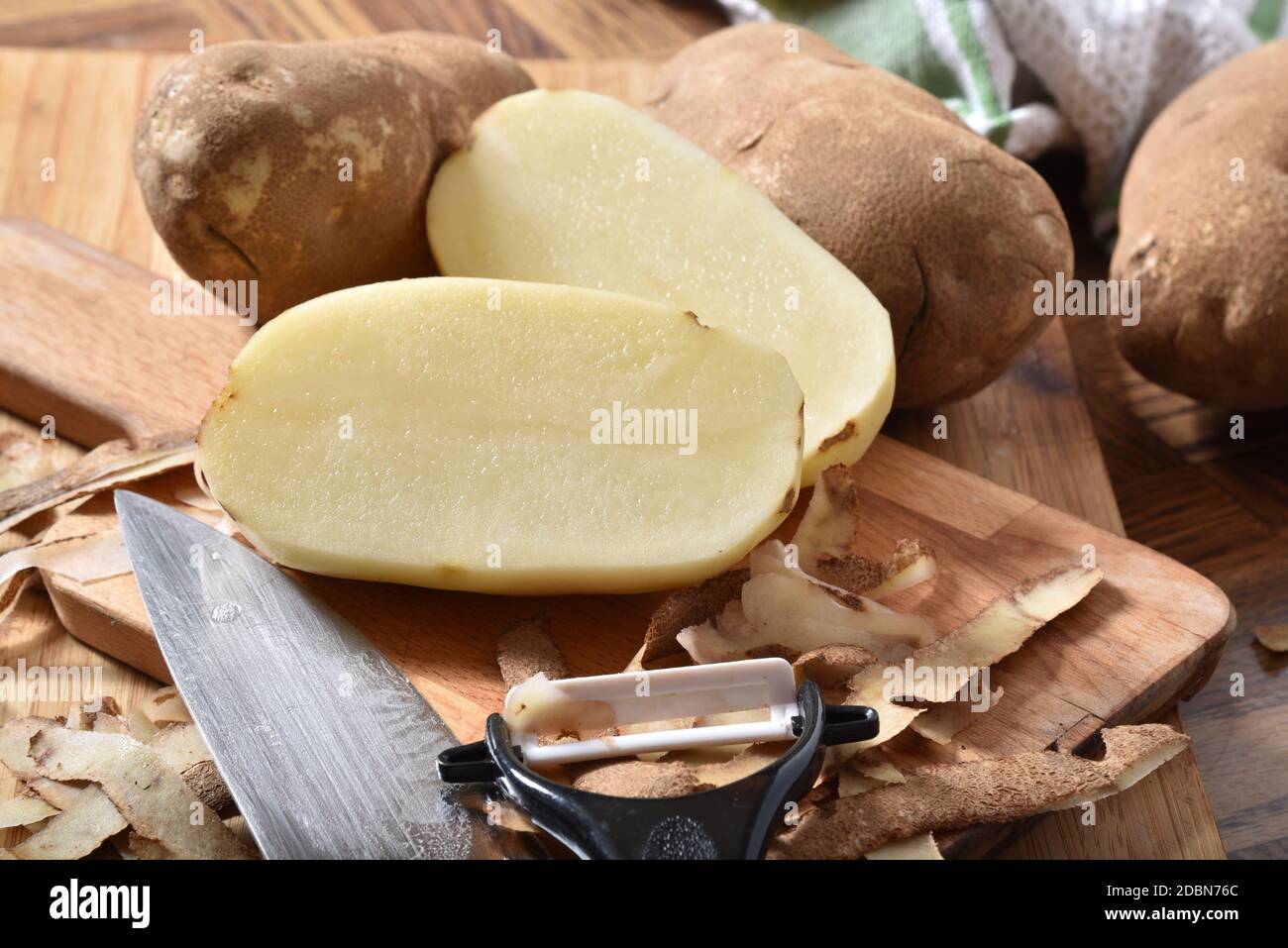 En pommes de terre Russet pelées et coupées sur une planche à découper Banque D'Images