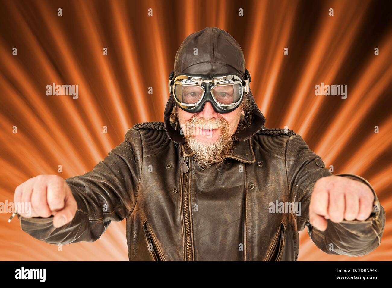 Composition de l'image avec vue frontale du haut du corps d'un homme plus âgé dans une veste de moto marron, portée, casquette de moto et lunettes de moto traditionnelles Banque D'Images