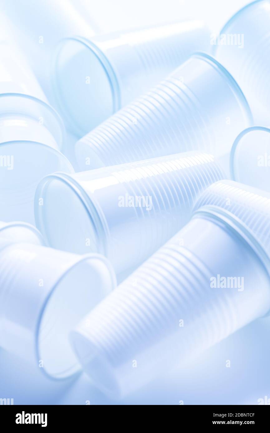 Tasses en plastique blanc jetables comme arrière-plan. Concept environnemental. Déchets non compostables. En bleu. Banque D'Images