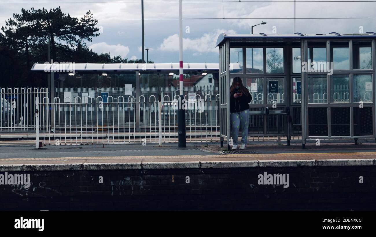 Une fille debout sur une plate-forme de train à la gare de Mill Hill Broadway. Banque D'Images