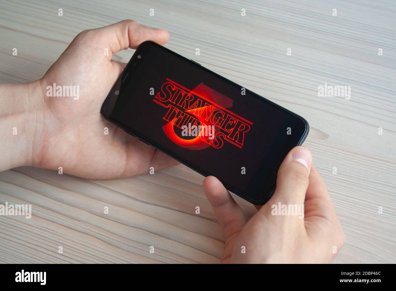 Photos de la série télé Stranger Things saison 3 sur la plate-forme de diffusion Netflix sur le téléphone dans les mains de l'homme. Photo d'illustration éditoriale de Pobul Banque D'Images