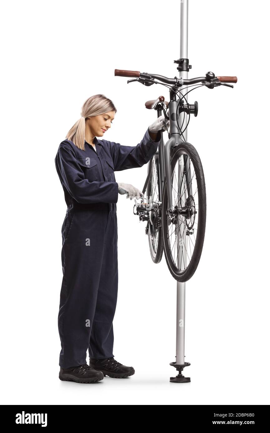 Plan en longueur d'une femme mécanique de vélo fixant un vélo sur un support isolé sur fond blanc Banque D'Images