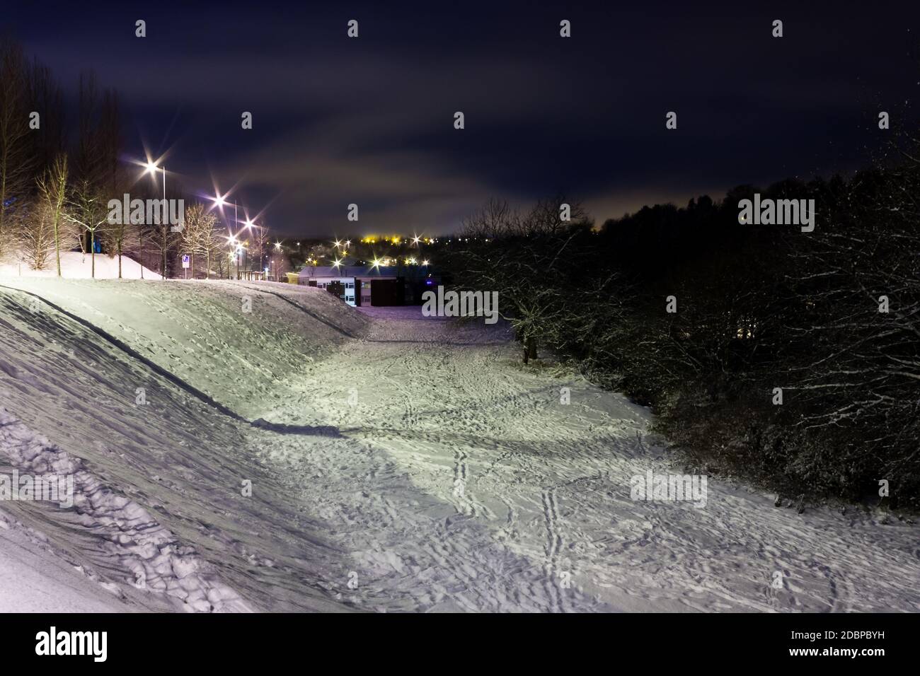La nuit, dans une petite ville, des routes enneigées ont été couvertes Banque D'Images