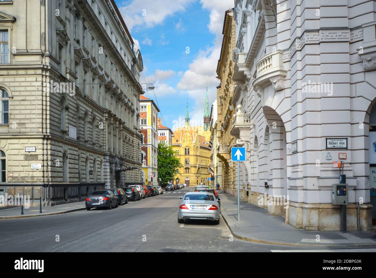 Les voitures se trouvent près de Bathory Utca, l'une des principales rues publiques près du Parlement avec l'église unitaire des clochers au loin Banque D'Images
