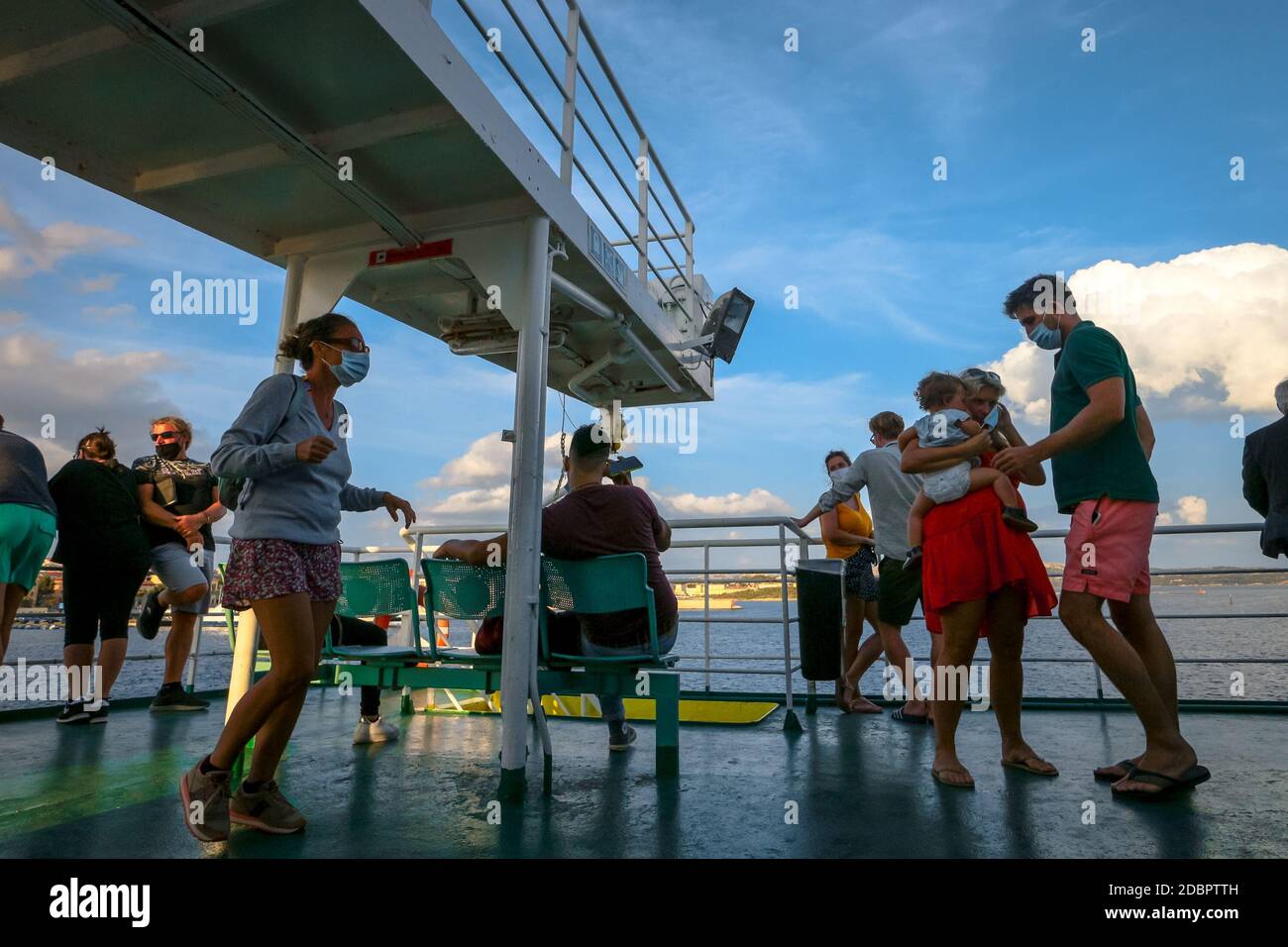 Passagers sur un ferry dans des masques faciaux pendant la crise du coronavirus à Olbia, Sardaigne, Italie. Banque D'Images