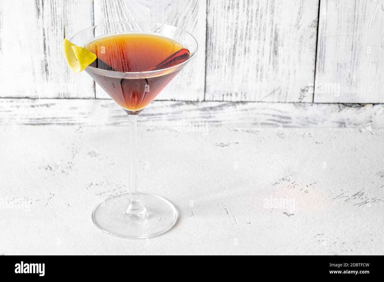 Verre de cocktail Martinez garni de zeste de citron Banque D'Images
