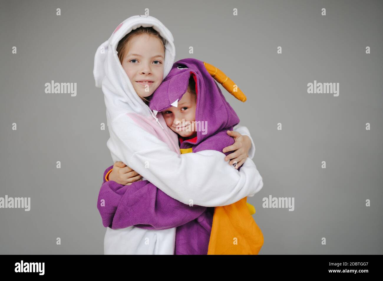 deux filles vêtues de lapin et de dragon posant devant un fond gris Banque D'Images