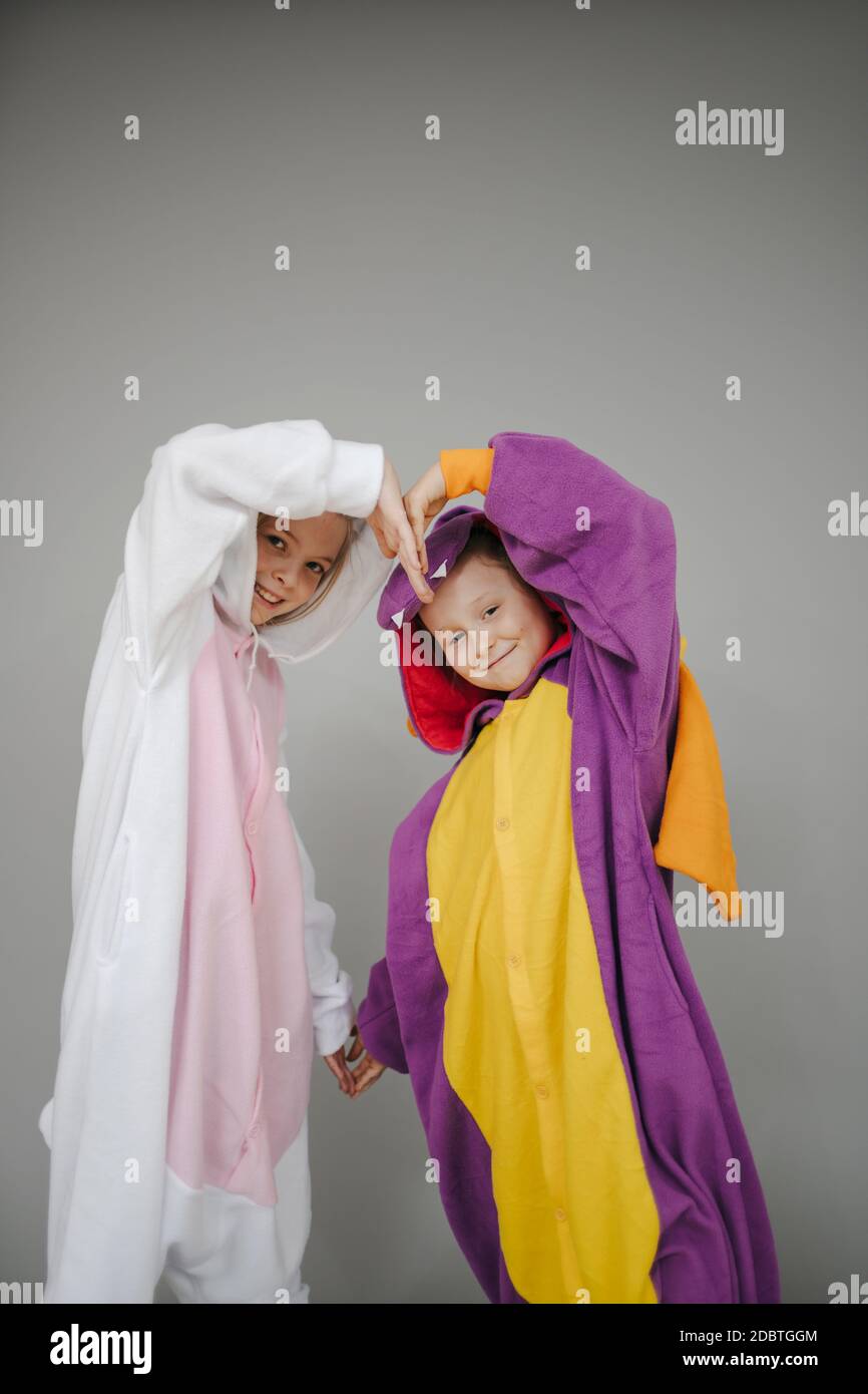 deux filles vêtues de lapin et de dragon posant devant un fond gris Banque D'Images