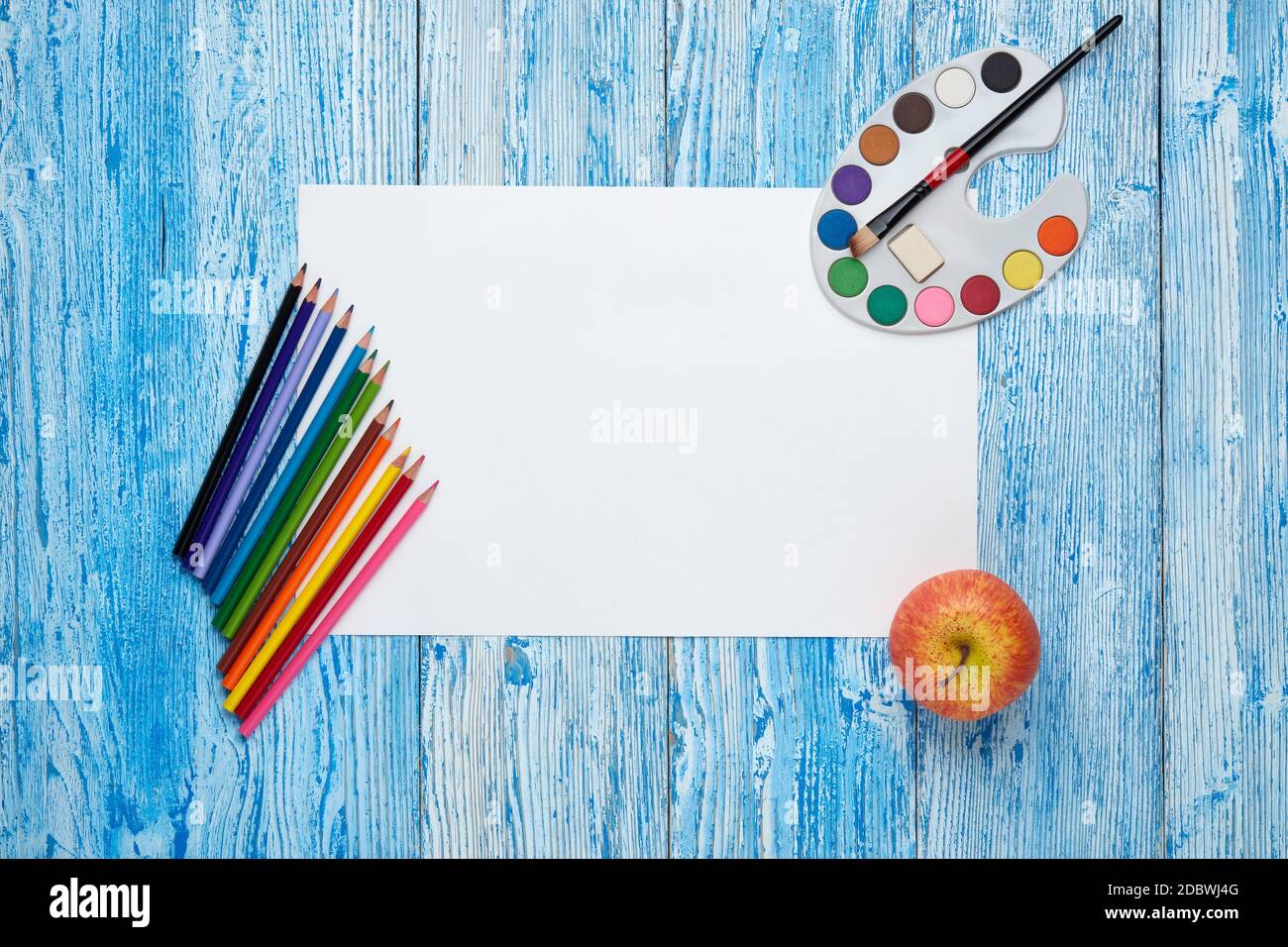 Feuille vierge, peintures et pinceaux sur fond en bois bleu. Vue de dessus, espace de copie. Accessoires scolaires pour l'éducation et le développement des enfants. AR Banque D'Images