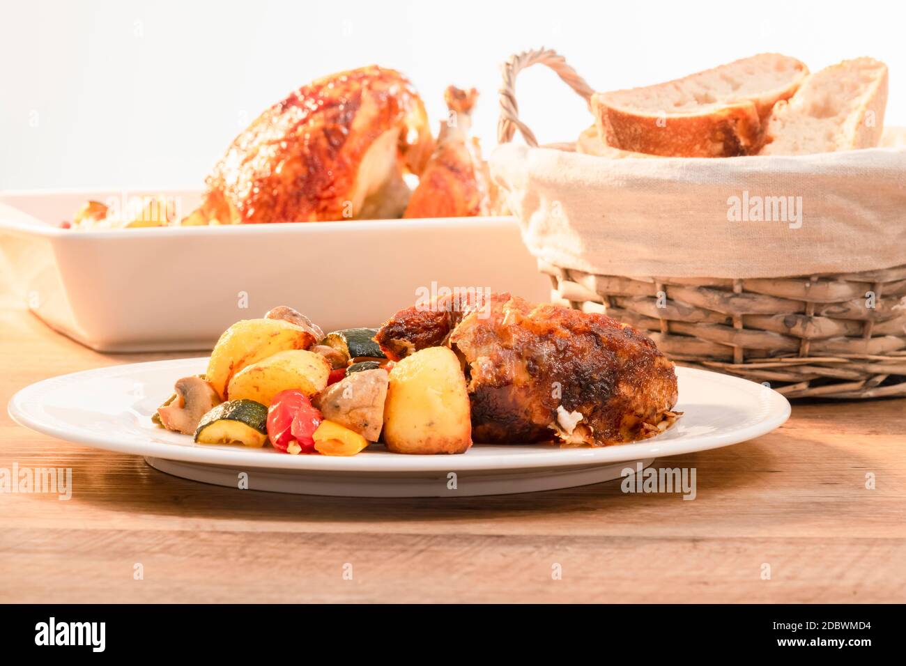 Mise au point sélective d'une assiette de poulet rôti avec des légumes avec  panier de pain hors foyer et plat de cuisson à l'arrière. Concept de  cuisine maison Photo Stock - Alamy