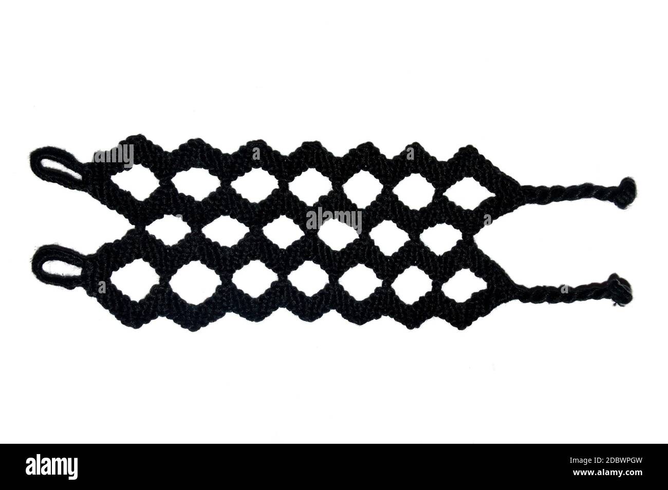 Bracelet d'amitié tissé noir Zigzag fait à la main de fil isolé sur fond blanc. Avec des queues de porc et des boucles Banque D'Images