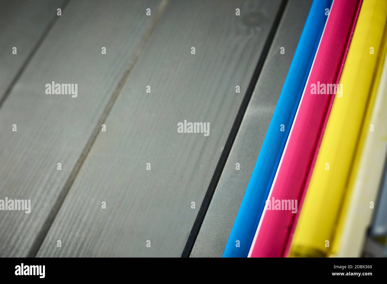 Vue latérale des rouleaux d'une imprimante laser cartouches couleur sur fond en bois gris Banque D'Images