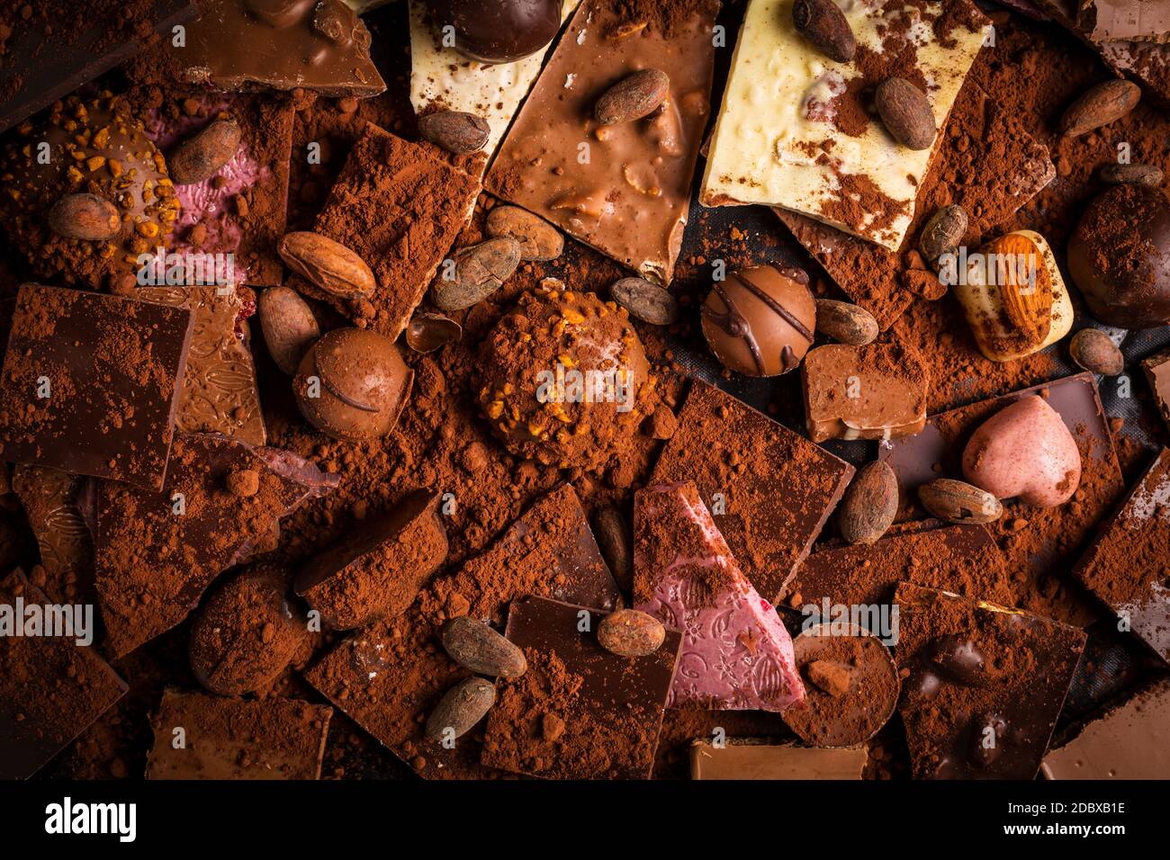 Variété de chocolat et de bonbons au chocolat avec cacao et cacao grains comme arrière-plan Banque D'Images