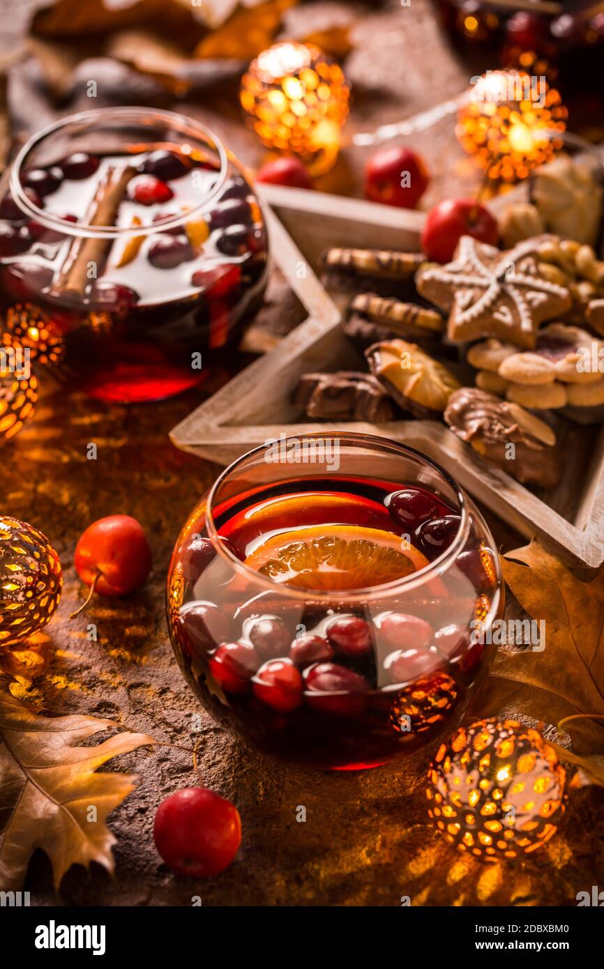 Vin chaud à l'orange, canneberges, cannelle, anis aux biscuits, feuilles d'automne et lumières de Noël Banque D'Images