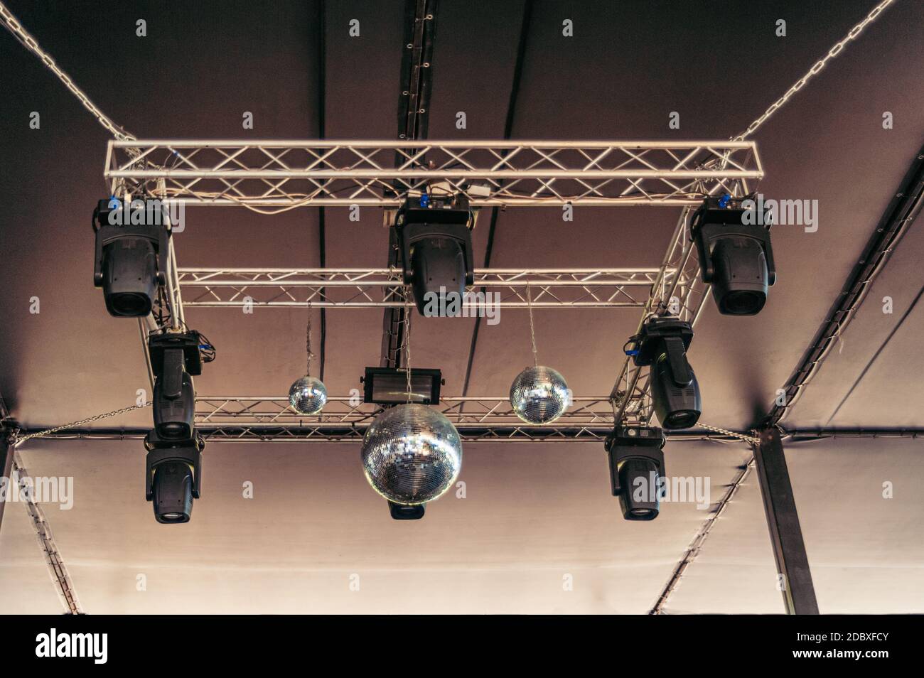 Plusieurs boules disco et lumières stroboscopiques pendent du plafond de la discothèque Banque D'Images