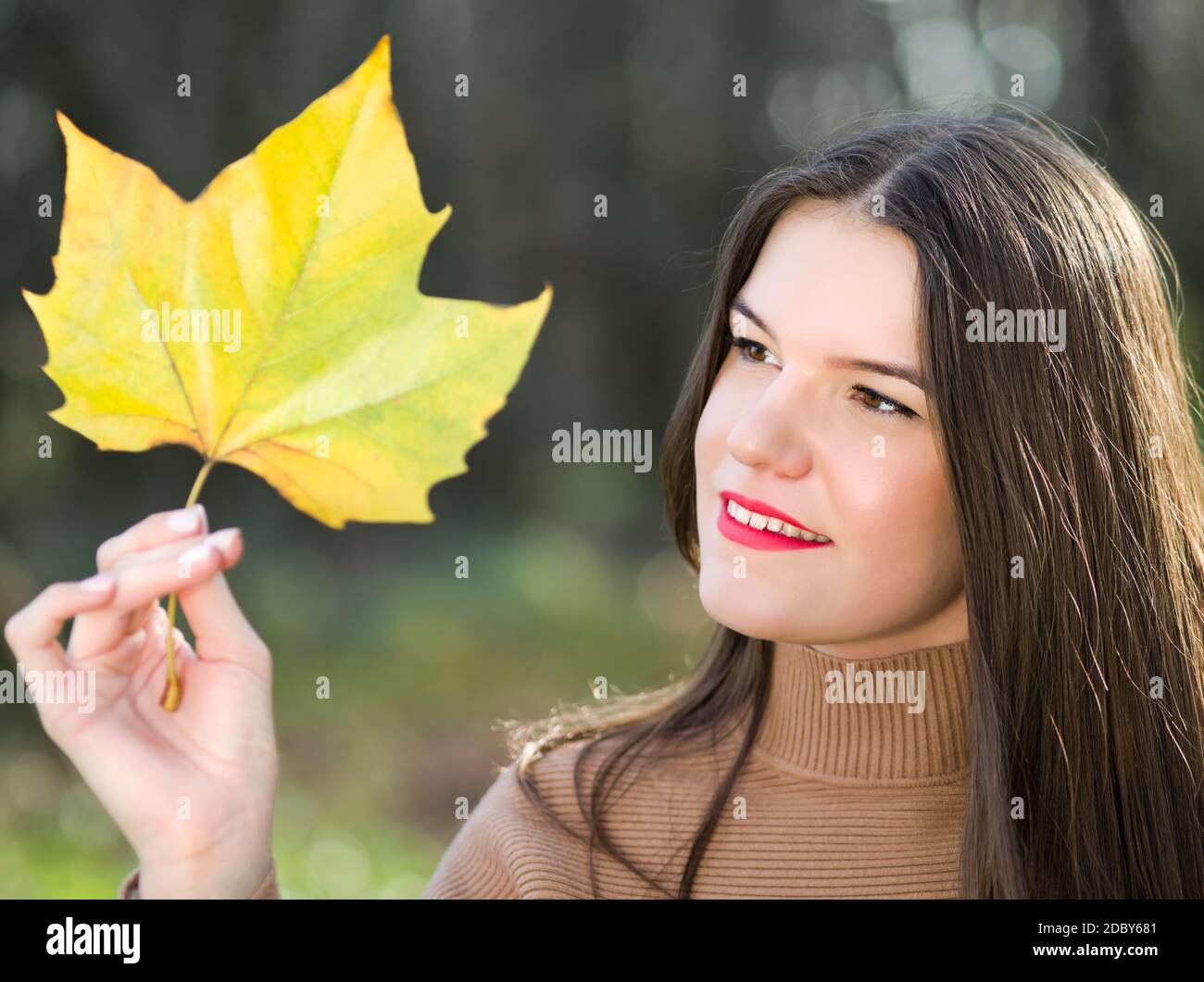 Portrait d'une jeune femme Brunette aux cheveux longs avec Feuille d'érable Banque D'Images