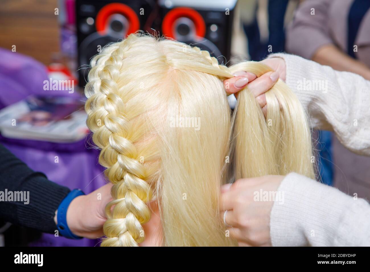 Tresse professionnelle de tresses par un coiffeur principal dans un salon de beauté. Le concept de soins capillaires. Banque D'Images