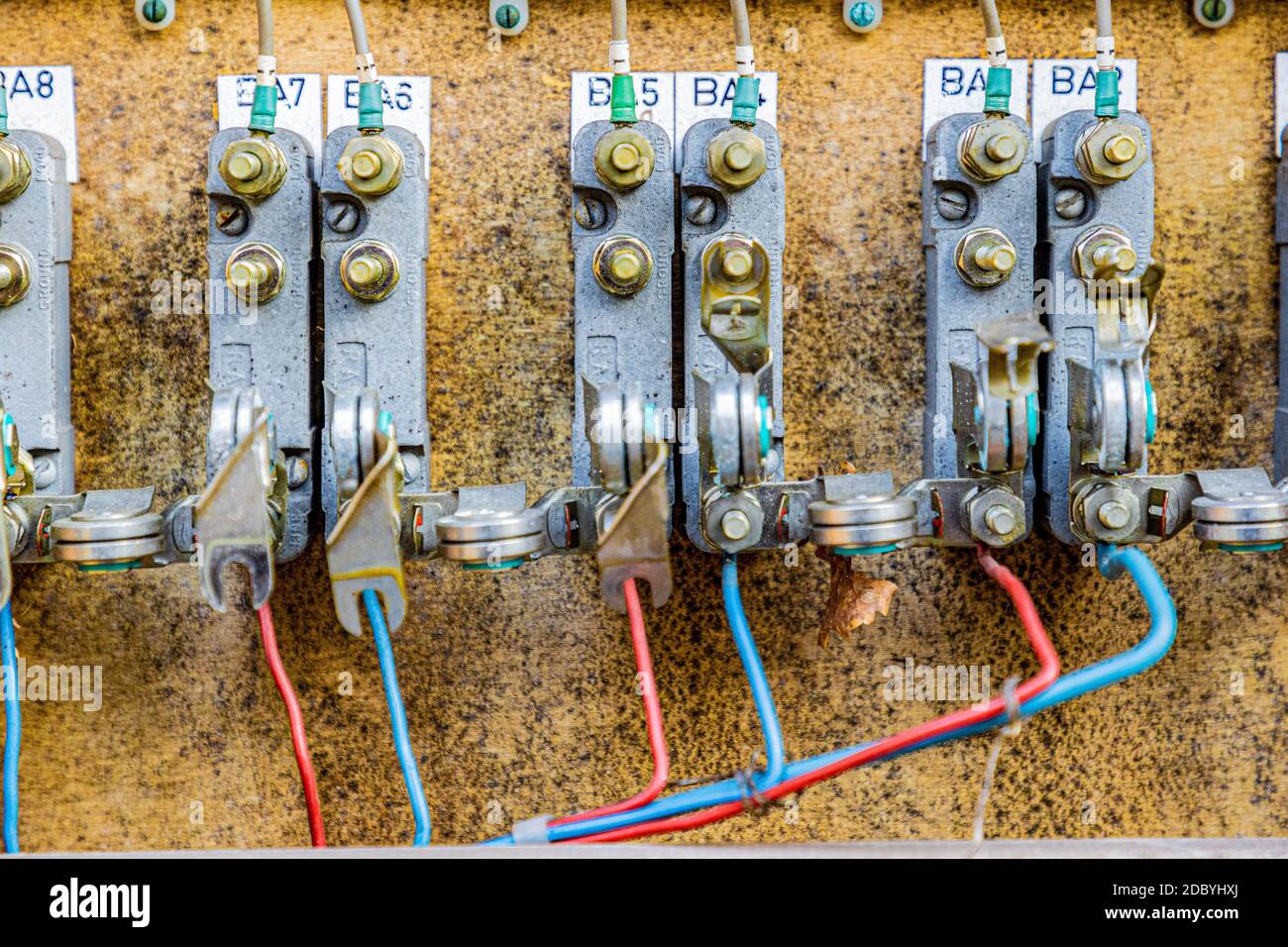 Gros plan d'une ancienne installation électrique dans une boîte à fusibles de relais de commande désutilisée de l'ancien chemin de fer du Rhin (IJzeren Rijn) fils rouges et bleus. Milieu L Banque D'Images