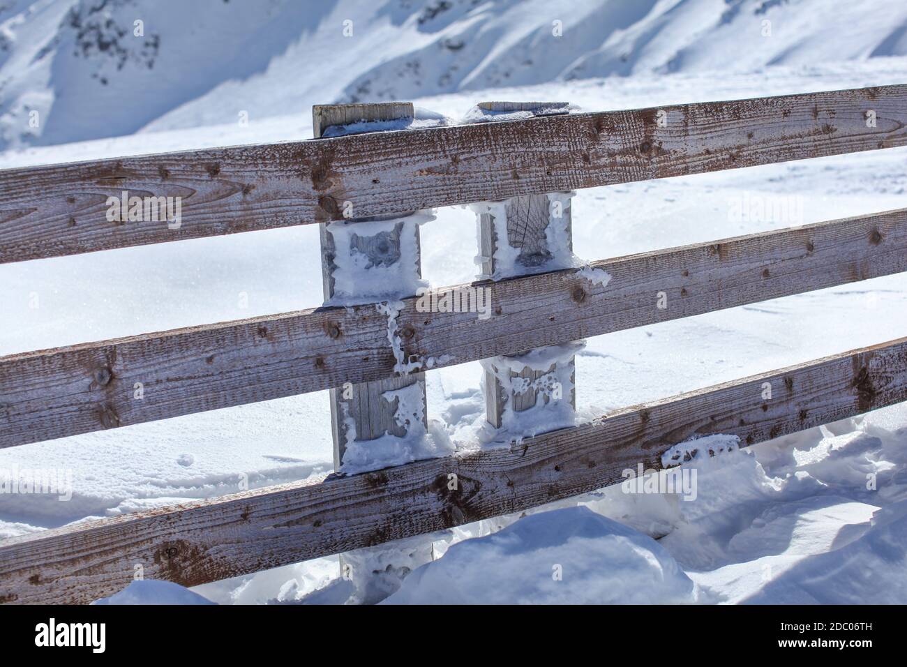 Clôture en bois profondément dans la neige lourde charge sur une journée ensoleillée. Banque D'Images