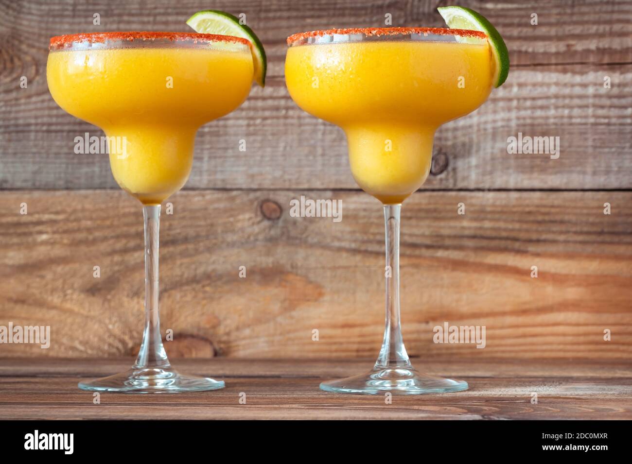 Verres de cocktails de mangue Margarita congelés garnis de sel de paprika jante Banque D'Images