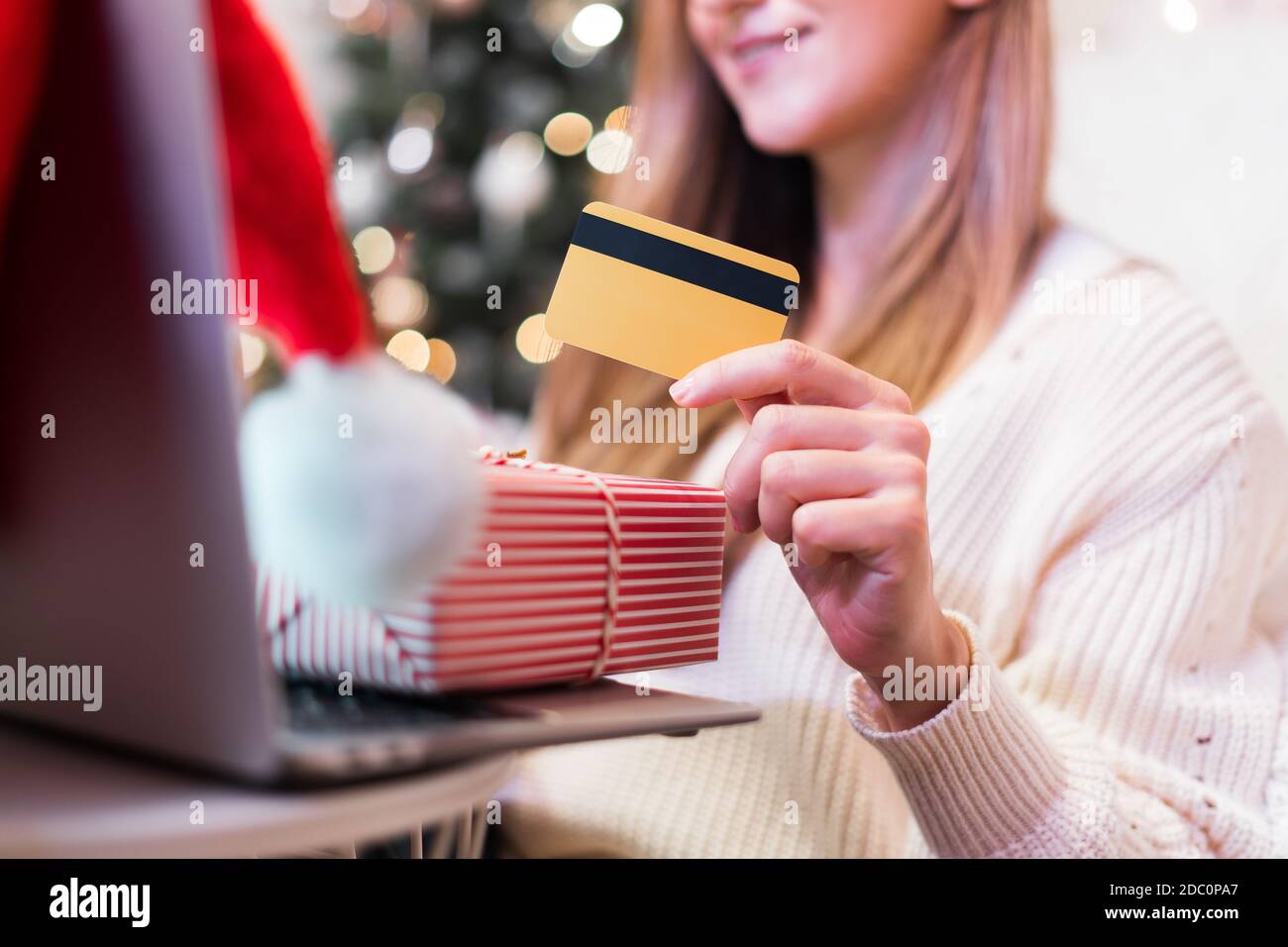 Gros plan des mains des femmes avec téléphone mobile, carte de crédit, cadeaux et ordinateur portable. Achats en ligne pendant les vacances de Noël. Femme freelance woking de la maison Banque D'Images